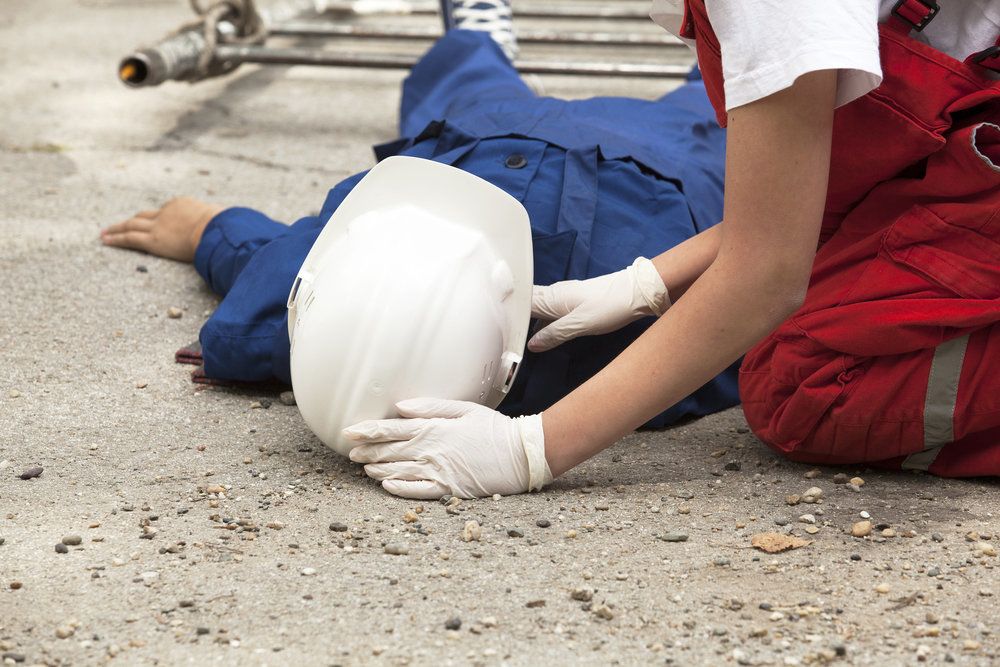 A man wearing a hard hat lying on the ground